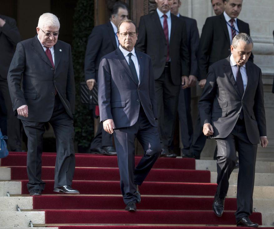 French President Francois Hollande, center, walks beside Iraqi President Fouad Massoum, left, after the opening of the International conference intended to come up with an international strategy against Islamic State extremists, in Paris, Monday, Sept. 15, 2014. As diplomats from around the world sought a global strategy to fight Islamic State extremists, Iran ruled out working with any international coalition, saying it had rejected American requests for cooperation against the militants. Man at right is undidentified. (AP Photo/Brendan Smialowski; Pool)