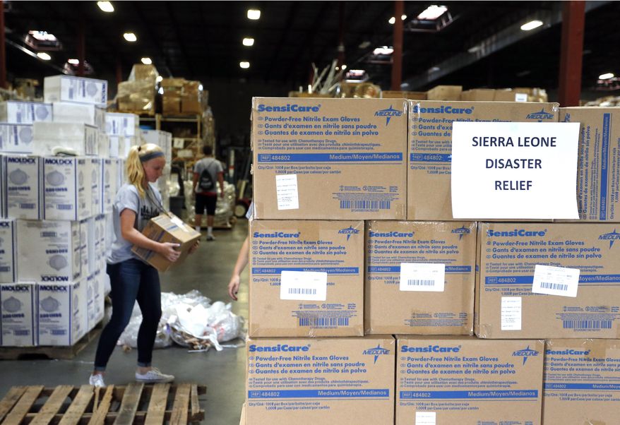 FILE - In this Sept. 9, 2014 file photo, Valor Christian High School sophomore and volunteer Paige Kula loads a pallet with medical supplies bound for Sierra Leone to combat Ebola, inside the warehouse of Project C.U.R.E., in Centennial, Colo. The US strategy in fighting Ebola is two-pronged: Step up efforts to deliver desperately needed supplies and people to West Africa, while making sure hospitals at home know what to do if someone travels here with the infection. In addition to shipments of hospital beds and protective suits, the government is taking unusual steps to encourage a variety of health care workers to volunteer to go to the outbreak zone _ and is offering some training before they head out. Here are questions and answers on the U.S. response. (AP Photo/Brennan Linsley, File)