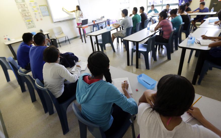 In this Wednesday, Sept. 10, 2014 photo, math is taught to high school students during a class at the Karnes County Residential Center, a temporary home for immigrant women and children detained at the border, in Karnes City, Texas. (AP Photo/Eric Gay)