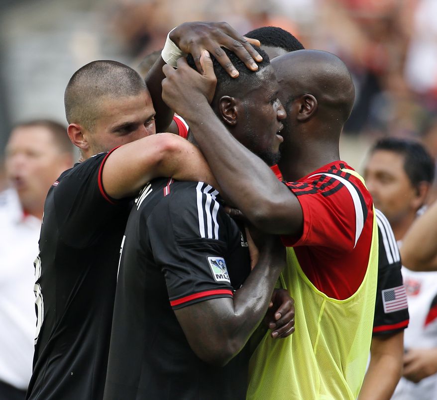 D.C. United forward Eddie Johnson, center, is embraced by his teammates after scoring during the second half of an MLS soccer match against the New York Red Bulls, at RFK Stadium, Sunday, Aug. 31, 2014, in Washington. United won 2-0. (AP Photo/Alex Brandon)