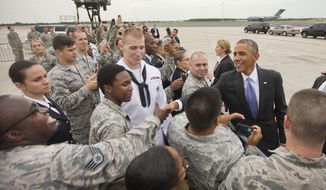 President Barack Obama greets members of the military upon his arrival on Air Force One at MacDill Air Force Base, Tuesday, Sept. 16, 2014. Obama will spend the night in Tampa and tomorrow morning he will receive a briefing at US Central Command about the ongoing military campaigns in Iraq and Syria. (AP Photo/Pablo Martinez Monsivais)