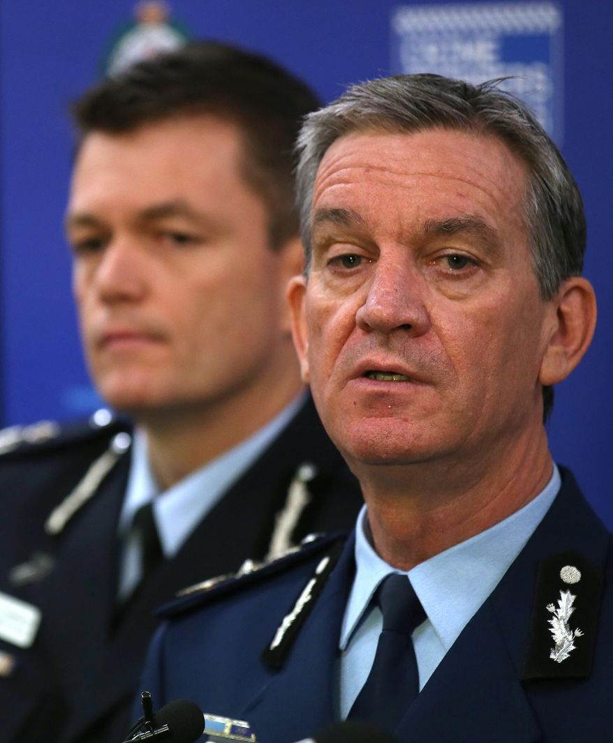 New South Wales Police Commissioner Andrew Scipione, right, and Australian Federal Police Acting Commissioner Andrew Colvin describe how 800 federal and state police officers raided more than two dozen properties as part of the operation in Sydney, Thursday, Sept. 18, 2014. Australian police detained 15 people earlier on Thursday in a major counterterrorism operation, saying intelligence indicated a random, violent attack was being planned on Australian soil. (AP Photo/Rick Rycroft)