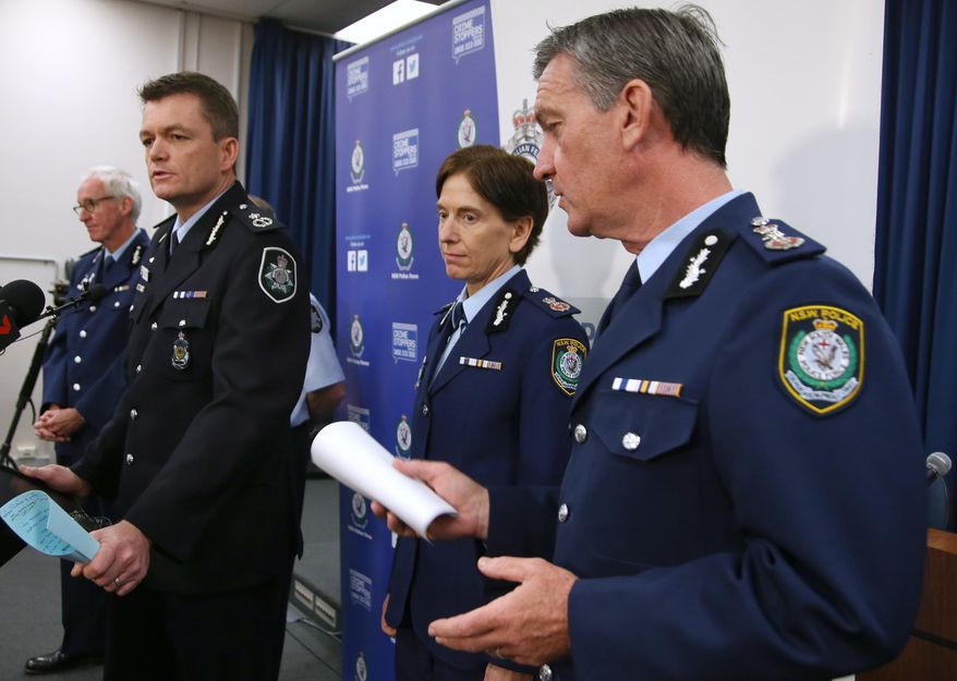 Australian Federal Police Acting Commissioner Andrew Colvin, left, and New South Wales Police Commissioner Andrew Scipione, right, describe how 800 federal and state police officers raided more than two dozen properties as part of the operation in Sydney, Thursday, Sept. 18, 2014. Australian police detained 15 people earlier on Thursday in a major counterterrorism operation, saying intelligence indicated a random, violent attack was being planned on Australian soil. (AP Photo/Rick Rycroft)