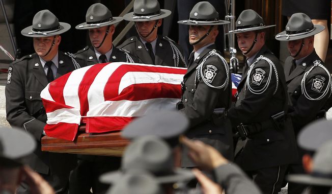 An honor guard carries the casket of Pennsylvania State Trooper Cpl. Bryon Dickson  from his funeral service, Thursday, Sept. 18, 2014, in Scranton, Pa. Dickson was killed on Friday night in an ambush shooting at the state police barracks in Blooming Grove Township. Authorities are looking for 31-year-old Eric Frein, of Canadensis, who has been charged with killing one trooper and wounding another outside the barracks. (AP Photo/Matt Slocum)