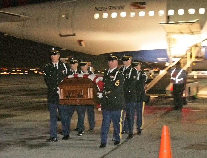 The remains of WWII casualty Montana Airman 1st Lt. William D. Bernier are carried from a Delta plane by a Honor Guard in Billings, MT Wednesday Sept. 17, 2014. Bernier will be buried in Augusta Saturday. (AP Photo/The Gazette, Bob Zellar)