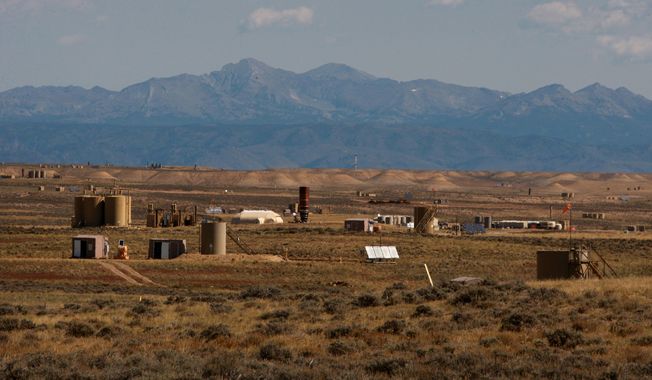 Natural gas wellhead huts, central delivery points and other infrastructure dot the Jonah Field on Monday, Sept. 8, 2014 near Pinedale, Wyo. Jonah Energy recently acquired Encana's natural gas assets in the area. (AP Photo/Casper Star-Tribune, Alan Rogers)