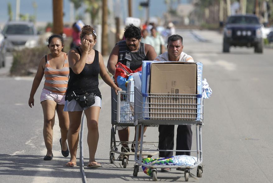 People carry looted goods taken from Walmart in Cabo San Lucas , Mexico, Wednesday, Sept. 17, 2014. Desperate locals and tourists were in survival mode in the resort area of Los Cabos on Wednesday, with electrical and water service still out three days after Hurricane Odile made landfall as a monster Category 3 storm. Looters stripped supermarkets of their food and other products, with some people fighting over goods. (AP Photo/Victor R. Caivano)