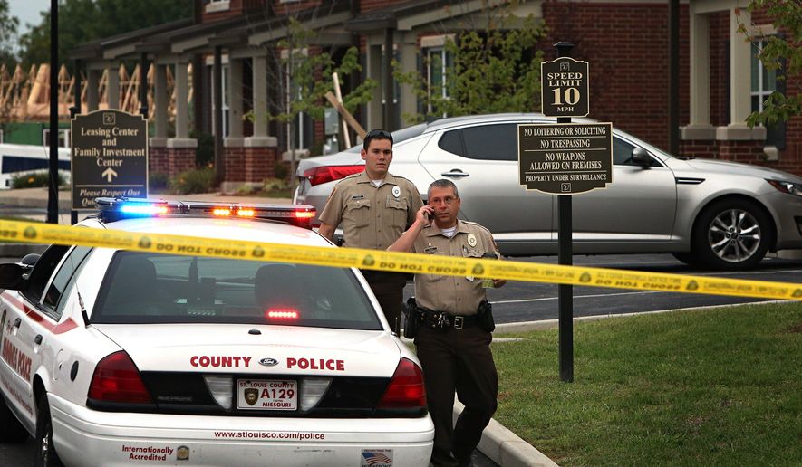 St. Louis County police officers investigate the scene of a fatal police officer involved shooting on Thursday, Sept. 18, 2014 in Jennings, Mo. St. Louis County Police Chief Jon Belmar said the officers fired a combined 25 shots at the suspect. The officers told Belmar the suspect tried to fire at them, but the rifle the suspect had, jammed. No casings from the suspect's .22-caliber rifle were found. This is the second fatal shooting of a black suspect by police in the region since the fatal August shooting of Michael Brown by a Ferguson, Mo., officer. (AP Photo/St. Louis Post-Dispatch, David Carson) EDWARDSVILLE INTELLIGENCER OUT; THE ALTON TELEGRAPH OUT