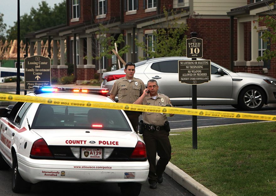 St. Louis County police officers investigate the scene of a fatal police officer involved shooting on Thursday, Sept. 18, 2014 in Jennings, Mo. St. Louis County Police Chief Jon Belmar said the officers fired a combined 25 shots at the suspect. The officers told Belmar the suspect tried to fire at them, but the rifle the suspect had, jammed. No casings from the suspect's .22-caliber rifle were found. This is the second fatal shooting of a black suspect by police in the region since the fatal August shooting of Michael Brown by a Ferguson, Mo., officer. (AP Photo/St. Louis Post-Dispatch, David Carson) EDWARDSVILLE INTELLIGENCER OUT; THE ALTON TELEGRAPH OUT