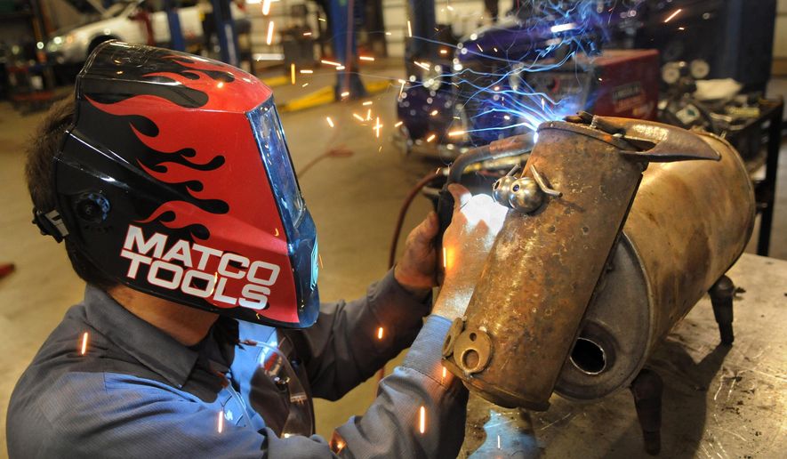 Tony Kizer, a technician at Happy's Stillwater Automotive Diagnostic Center in Stillwater, Minn. welds a neck on a cow during his lunch break Wednesday, Sept. 10, 2014. He designed the cow using mufflers, combine farm implements and ball joints and a bulletin board peg holder for the eyebrows. (AP Photo/St. Paul Pioneer Press, Jean Pieri)