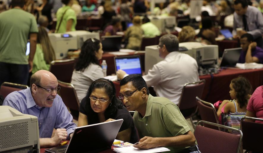 FILE - In this Sept. 3, 2014 file photo, former Revel Hotel Casino employees, Jignasha Shah, 45, center, and Ranjitsinh Rana, 56, right, get help from John McCaffery, as they and thousands of other newly laid-off casino workers file for unemployment benefits at the Atlantic City Convention Center in Atlantic City, N.J. The government reports on state unemployment rates for August on Friday, Sept. 19, 2014. (AP Photo/Mel Evans, File)