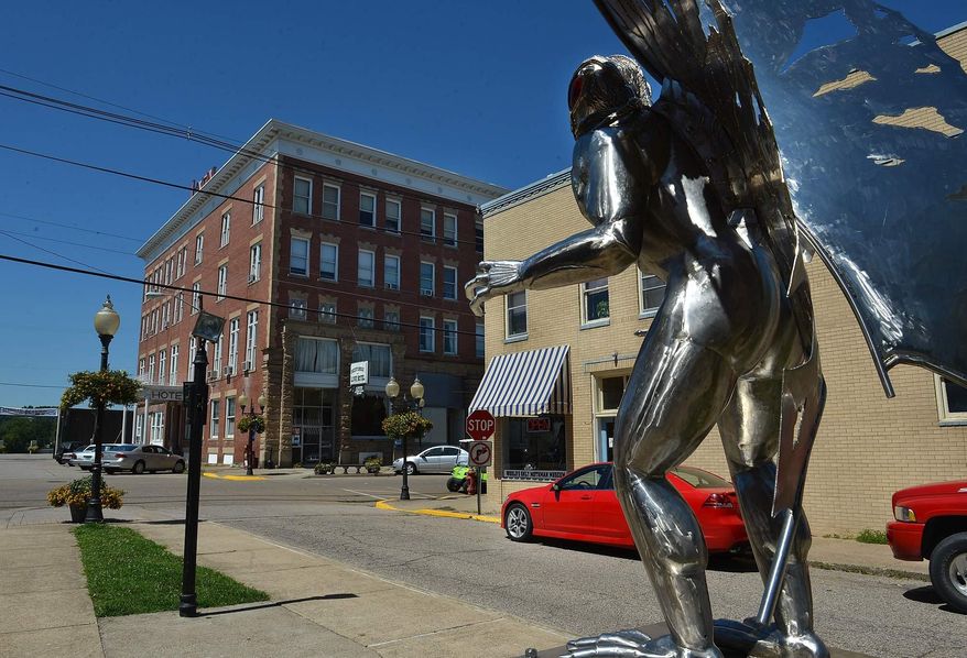 ADVANCE FOR SUNDAY SEPT 21 AND THEREAFTER This Aug. 28, 2014 shows the Mothman Museum, relocated last month to a new storefront just across from the town's famous chrome Mothman statue in Point Pleasant, W.Va. The museum will mark its grand re-opening this Saturday at 9:45 a.m., as part of the 13th annual Mothman Festival. The new, larger space has plenty of room to spread out spacey memorabilia, allowing the museum to better organize its exhibits. (AP Photo/Charleston Daily Mail, Craig Cunningham)