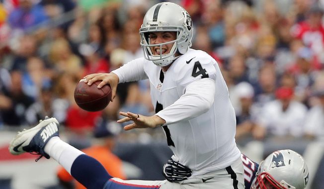 New England Patriots defensive end Rob Ninkovich (50) tries to take down Oakland Raiders quarterback Derek Carr (4) in the first half of an NFL football game, Sunday, Sept. 21, 2014, in Foxborough, Mass. (AP Photo/Elise Amendola)