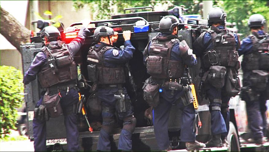 FILE - In this July 6, 2013 file still photo from a video produced by the Los Angeles Police Department, officers ride on an armored medical rescue vehicle in a drill simulating a terrorist attack in downtown Los Angeles. A Pentagon program that distributes military surplus gear to local law enforcement agencies permits even those departments that the Justice Department has censured for civil rights violations to apply for and receive lethal weaponry. That lack of communication between two parts of the federal government adds to questions about a program already facing an Obama administration review in the aftermath of the militarized police response to protesters in Ferguson, Missouri. The. (AP Photo/Los Angeles Police Department, File)