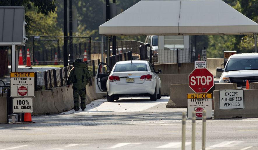 An explosive technician in a bomb suit approaches a vehicle near the entrance to White House in Washington, Saturday. The Secret Service says two men were arrested in separate recent incidents for trying to unlawfully enter the White House. (AP Photo/Pablo Martinez Monsivais)