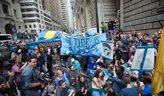 Demonstrators stage a sit-in Monday on Broadway during a march protesting for action on climate change. (Associated Press)