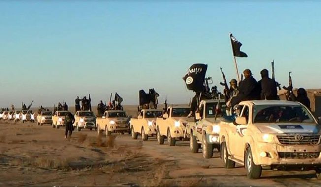 This file image posted on a militant website on Tuesday, Jan. 7, 2014, which is consistent with AP reporting, shows a convoy of vehicles and fighters from the Islamic State group in Iraq&#x27;s Anbar Province. (AP Photo via militant website, File)