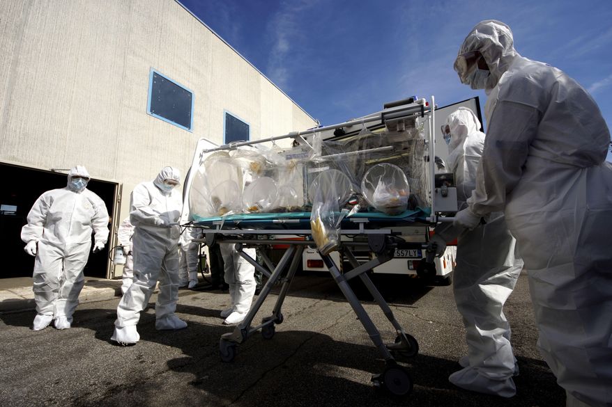 Participants into a course to learn how to transport and handle contagious patients use an 'Aircraft Transit Isolator' (ATI) to carry a colleague during a simulation at the military airport of Pratica di Mare, 30 kilometers south of Rome, Wednesday, Sept. 24, 2014. Italy's defense ministry staged the simulated medical evacuation of an Ebola patient Wednesday as part of a three-day training course for Italian military, Red Cross and health care workers. Some of them are on the front lines of Italy's Mare Nostrum rescue operation for thousands of African migrants who are arriving here every day in smugglers' boats. Officials and medical experts insist that the risk that Ebola might spread from Africa to Europe is small. They say Italy's first case of Ebola will most likely be from an Italian doctor or missionary who contracts it while caring for patients in Liberia, Sierra Leone or Guinea _ the three hardest-hit countries _ and is airlifted home. (AP Photo/Domenico Stinellis)