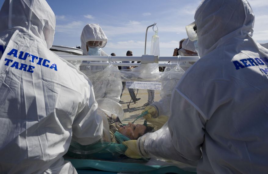 Participants into a course to learn how to transport and handle contagious patients use an 'Aircraft Transit Isolator' (ATI) to carry a colleague during a simulation at the military airport of Pratica di Mare, 30 kilometers south of Rome, Wednesday, Sept. 24, 2014. Italy's defense ministry staged the simulated medical evacuation of an Ebola patient Wednesday as part of a three-day training course for Italian military, Red Cross and health care workers. Some of them are on the front lines of Italy's Mare Nostrum rescue operation for thousands of African migrants who are arriving here every day in smugglers' boats. Officials and medical experts insist that the risk that Ebola might spread from Africa to Europe is small. They say Italy's first case of Ebola will most likely be from an Italian doctor or missionary who contracts it while caring for patients in Liberia, Sierra Leone or Guinea _ the three hardest-hit countries _ and is airlifted home. (AP Photo/Domenico Stinellis)