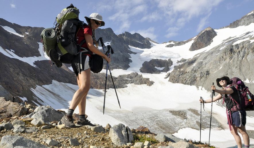 FILE - In this August 2013 file photo, Holly Weiler, left, and Samantha Journot of the Spokane Mountaineers hike past Lyman Glacier as they head toward Spider Gap to complete a loop backpacking trek in Washington state&#39;s Glacier Peak Wilderness. The U.S. Forest Service is proposing rules that restrict filming and photography by media organizations and others in more than 100 million acres of the nation&#39;s wilderness, Wednesday, Sept. 24, 2014.  (AP Photo/The Spokesman-Review, Rich Landers, File) COEUR D&#39;ALENE PRESS OUT