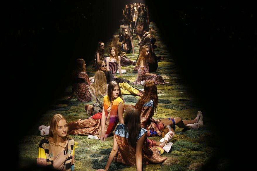 Models sit on the catwalk during Dries van Noten's Spring/Summer 2015 ready-to-wear fashion collection presented in Paris, France, Wednesday, Sept. 24, 2014. (AP Photo/Jacques Brinon)