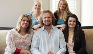 In this July 10, 2013, file photo, Kody Brown poses with his wives — one is legally his wife and the other are &quot;sister wives&quot; — at one of their homes in Las Vegas. Utah&#x27;s attorney general has filed notice that he will appeal a ruling striking down parts of the state&#x27;s anti-polygamy law in a lawsuit brought by the family on the TLC reality TV show, &quot;Sister Wives.&quot; Attorney General Sean Reyes filed the notice Wednesday, about a month after a federal judge issued a final ruling in the case. (AP Photo/Las Vegas Review-Journal, Jerry Henkel/File)