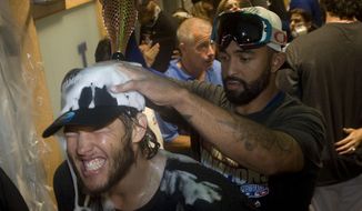 The Dodgers&#39; Clayton Kershaw has champagne poured over his head my Matt Kemp after the Dodgers clinched the National League West against the San Francisco Giants at Dodger Stadium Wednesday nightSept. 24, 2014. The Los Angeles Dodgers won the NL West title with a 9-1 victory over the second-place San Francisco Giants on Wednesday night. (AP Photo/The Orange County Register, Kevin Sullivan)