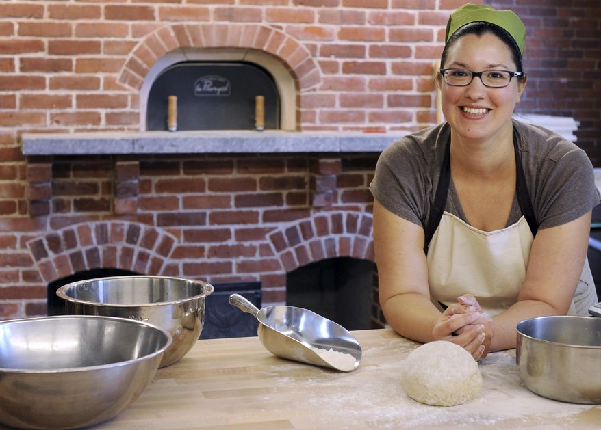 ADVANCE FOR SUNDAY, SEPT. 28, 2014 AND THEREAFTER -- In this Tuesday, Sept. 16, 2014 photo food historian and artisan baker Tani Mauriello stands with baking materials in the new Artisan Craft Center, at the Plimoth Plantation museum, in Plymouth, Mass. The bakery, where visitors will be able to get a taste of 17th-century living, was added during the renovation of the museum's Craft Center inside the former Hornblower Carriage House. (AP Photo/Cape Cod Times/Christine Hochkeppel) MANDATORY CREDIT