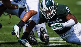 Michigan State freshman defensive back Montae Nicholson tackles Eastern Michigan senior wide receiver Tyler Allen as grass flies up from his cleat on Saturday, Sept. 20, 2014 at Spartan Stadium in East Lansing. Michigan State won 73-14. (AP Photo/The Flint Journal, Jake May)