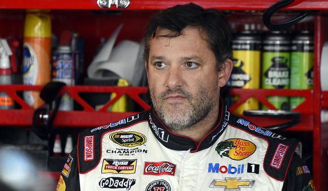 In this Sept. 13, 2014, file photo, Tony Stewart looks out from his garage during practice for the NASCAR Sprint Cup series auto race at Chicagoland Speedway in Joliet, Ill. A grand jury decided against charging Stewart in the death of Kevin Ward Jr. on a dirt track last month in upstate New York. Stewart took three weeks off from racing after the crash. (AP Photo/Paul J. Bergstrom, File)
