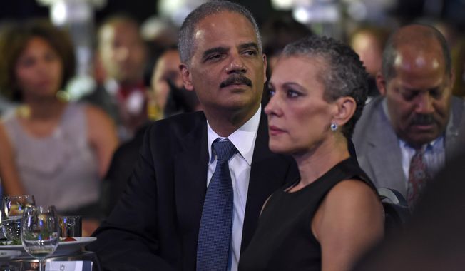 Attorney General Eric Holder, center, sits with his wife Sharon Malone, right, as they wait for President Barack Obama to speak at the Congressional Black Caucus Foundation’s 44th Annual Legislative Conference Phoenix Awards Dinner in Washington, Saturday, Sept. 27, 2014. Obama told the audience that the mistrust of law enforcement that was exposed after the fatal police shooting in Ferguson, Missouri, has a corrosive effect on all of America, not just on black communities. (AP Photo/Susan Walsh)