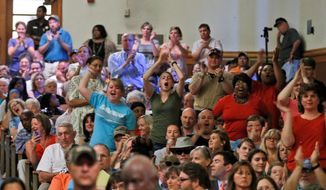 Area residents cheer as statements are made  during a presentation by federal officials involved in the placement of immigrant children at St Paul&#39;s College in Lawrenceville, Va., Thursday, June 19, 2014. The program is on hold pending comments from local residents (AP Photo/Steve Helber)