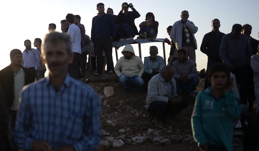 Turkish Kurds watch clashes between Syrian Kurdish fighters and militants of the Islamic State close to Turkey-Syria border near Suruc, Turkey, Sunday, Sept. 28, 2014. (AP Photo)