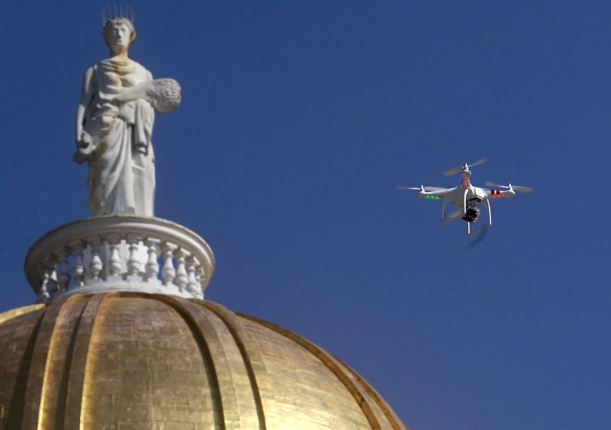 FILE - In this Sept. 17, 2013 file photo, a drone is flown over the Statehouse in Montpelier, Vt., in support of legislation by the state chapter of the American Civil Liberties Union that would regulate surveillance of private citizens by law enforcement agencies. A hearing is scheduled for Oct. 21, 2014, on a different proposal by the Fish and Wildlife Board, which governs hunting in the state, to preemptively ban hunting with drones or from other types of aircraft. (AP Photo/Toby Talbot, File)