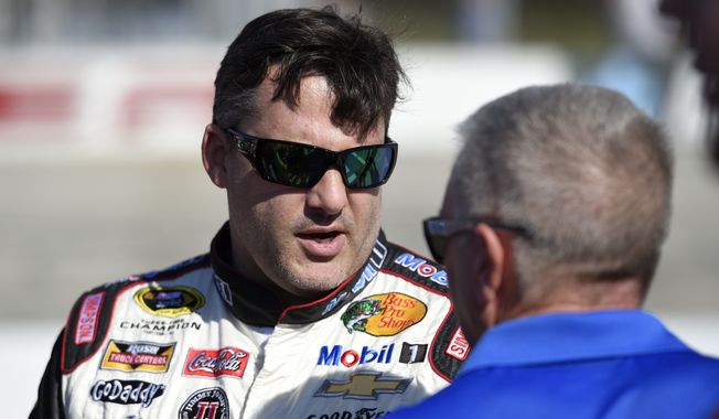 Tony Stewart, left, talks on pit road before qualifying for the NASCAR Sprint Cup series auto race, Friday, Sept. 26, 2014, at Dover International Speedway in Dover, Del. (AP Photo/Nick Wass)