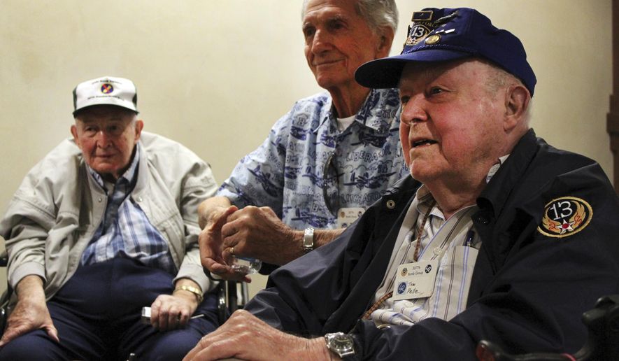 In this Sept. 18, 2014 photo, World War II veterans, from left, Earl McGuire, Jack Palmer and Tom Pelle talk about their service with the 307th Bombardment Group during a reunion in Santa Fe, N.M. Pelle and the few other remaining members of the 13th Air Force's famous 307th Bombardment Group, their family members and Ancestry.com’s military records site Fold3 are working to keep alive the group’s memory by collecting and digitizing thousands of photographs, military orders and other memorabilia. The records are being posted online as part of a searchable database. (AP Photo/Susan Montoya Bryan)
