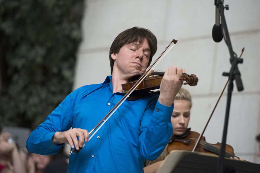 Acclaimed violinist Joshua Bell performs with young musicians who are alumni of the National YoungArts Foundation (YoungArts) during a performance, Tuesday, Sept. 30, 2014, at Union Station in Washington. Seven years ago, Bell performed incognito for tips in a Washington subway station, but almost no one stopped to listen. The subway performance was an experiment with The Washington Post to see if anyone would notice some of the world's great music during their rush to work. It made for a good story that eventually won the Pulitzer Prize and inspired a children's book and even mentions in church sermons. (AP Photo/Molly Riley)