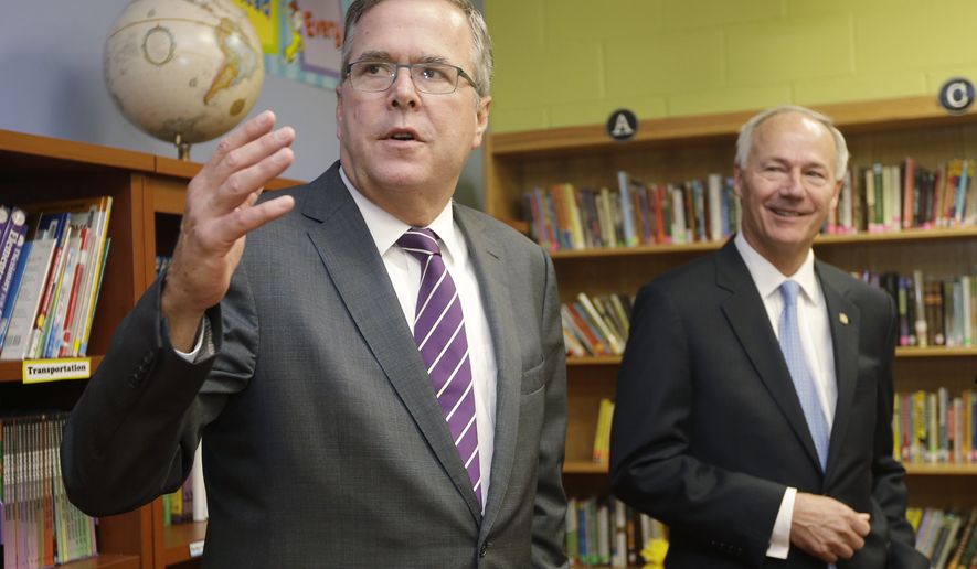 Former Florida Gov. Jeb Bush, left, speaks to reporters as Republican candidate for Arkansas governor Asa Hutchinson listens in the library at LISA Academy North in Sherwood, Ark., Tuesday, Sept. 30, 2014. Bush, potential 2016 GOP presidential candidate, steps up campaigning for Republicans in tight races ahead of the midterm elections.  (AP Photo/Danny Johnston)