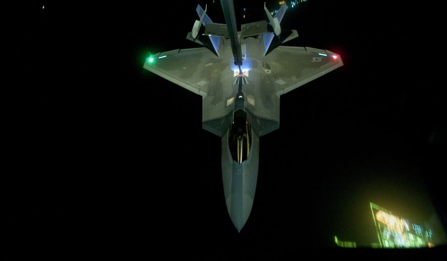 In this Friday, Sept. 26, 2014 photo, released by the U.S. Air Force, a U.S Air Force KC-10 Extender refuels an F-22 Raptor fighter aircraft prior to strike operations in Syria. The F-22s, making their combat debut, were part of a strike package that was engaging Islamic State group targets in Syria. Washington and its Arab allies opened the air assault against the extremist group on Sept. 23, striking military facilities, training camps, heavy weapons and oil installations. The campaign expands upon the airstrikes the United States has been conducting against the militants in Iraq since early August. (AP Photo/U.S. Air Force, Russ Scalf )