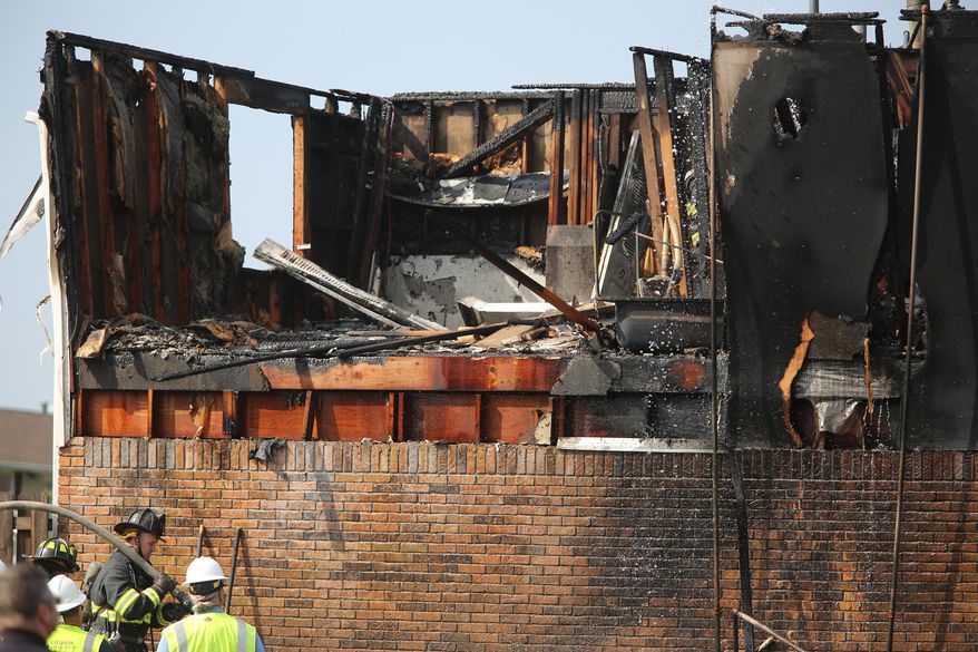 Firefighters work the scene of an explosion and fire at the Berkshire Square apartment complex in Cumberland, Ind., east of Indianapolis, on Wednesday, Oct. 1, 2014. Fire officials say a 20-year-old man and a 13-year-old boy were hospitalized in critical condition. (AP Photo/The Indianapolis Star, Kelly Wilkinson) NO SALES
