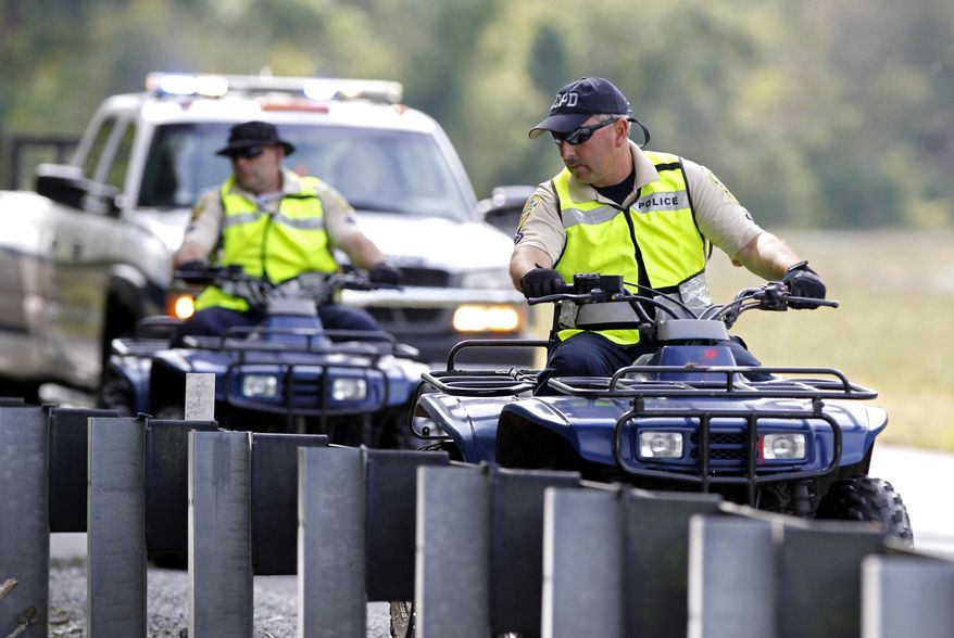 Albemarle County Police riding all-terrain vehicles perform a search along the edge of Monacan Trail Road on Sunday, Sept. 28, 2014. Hannah Elizabeth Graham, 18, a second-year University of Virginia student, went missing Sept. 13. (AP Photo/The Daily Progress, Ryan M. Kelly)