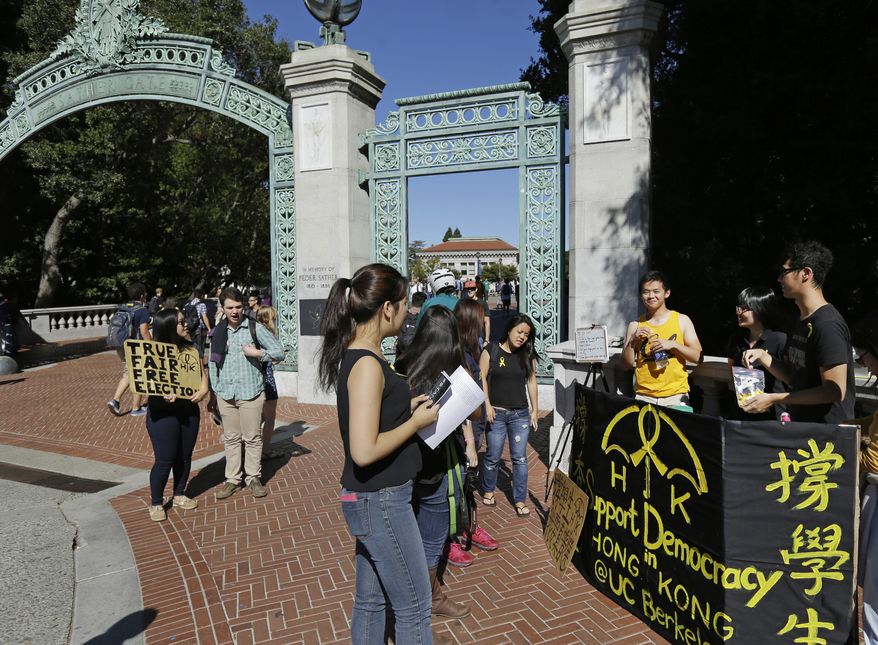 University of California at Berkeley students pass out yellow ribbons and educate others  in support for the Umbrella Revolution, a group seeking democracy in Hong Kong, on Wednesday, Oct. 1, 2014, at Sather Gate in Berkeley, Calif. Student leaders of Hong Kong&#x27;s pro-democracy protests warned that if the territory&#x27;s top official doesn&#x27;t resign by Thursday they will step up their actions, including occupying several important government buildings. By raising the stakes in the standoff, the protesters are risking another round of confrontation with police, who are unlikely to allow government buildings to be stormed. It also puts pressure on the Chinese government, which so far has said little beyond declaring the protests illegal and backing Hong Kong Chief Executive Leung Chun-ying&#x27;s attempts to end them. (AP Photo/Ben Margot) **FILE**