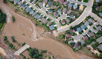 Floodwaters cut a residential neighborhood in two last year in Lyons, Colorado. Thousands of people living along Front Range were forced to evacuate. The freak storm, however, was not a result of man-made climate change, a scientific study shows. (Associated Press)