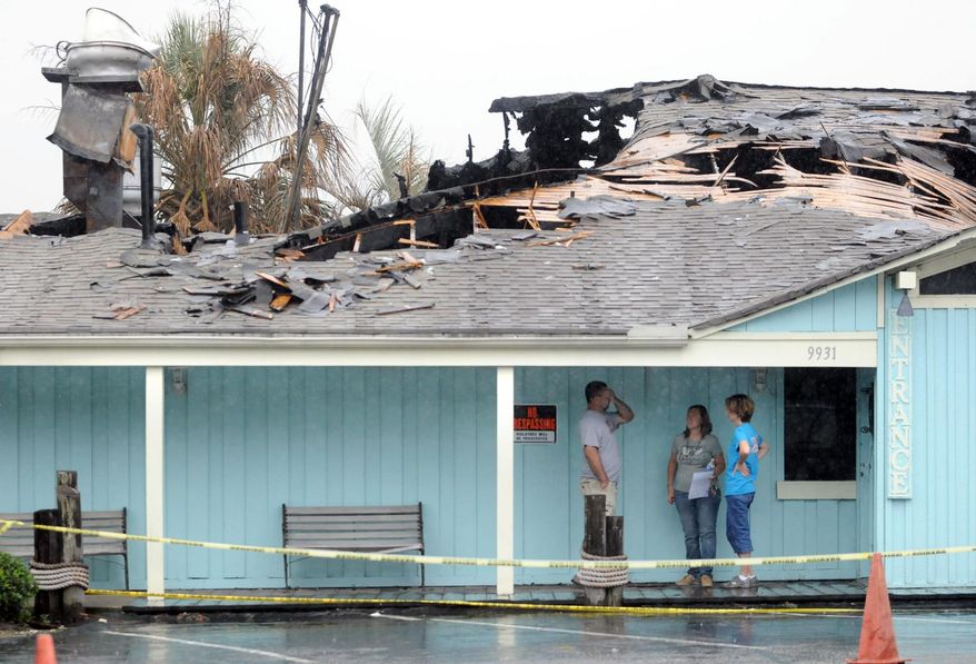 From left, Adam Nixon, Crystal Coleman-Nixon and Julie Hinkle discuss construction on the porch outside Coleman's Original Calabash Restaurant on Sept. 15, 2014 in Calabash, N.C. An electrical fire consumed the better part of Coleman's Original Calabash Restaurant, one of the county's oldest eateries with a history dating to 1940.(AP Photo/The Star-News, Matt Born) LOCAL TELEVISION OUT; LOCAL INTERNET OUT