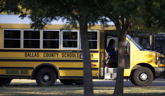 A Dallas Independent School District bus departs L.L. Hotchkiss Elementary school after dropping off students, Thursday, Oct. 2, 2014, in Dallas. Hotchkiss has been identified by the Dallas Independent School District as one of the schools where one or more of the students attend that came in contact with the man diagnosed with having the Ebola virus. (AP Photo/Tony Gutierrez)