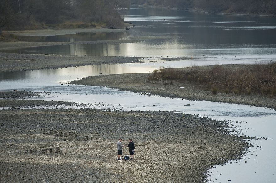In this Saturday, Jan. 11, 2014 photo, two fishermen stand near the shallow water of the American River below Watt Ave, in Sacramento, Calif., which has experienced drought-like conditions this year. State and federal wildlife officials are resorting to installing giant water chillers in some of California's fish hatcheries, as drought, over-allocation of water and climate change all combine this year to make temperatures too warm for some baby salmon and other fish to survive. (AP Photo/The Sacramento Bee, Randall Benton) MAGS OUT; LOCAL TELEVISION OUT (KCRA3, KXTV10, KOVR13, KUVS19, KMAZ31, KTXL40); MANDATORY CREDIT