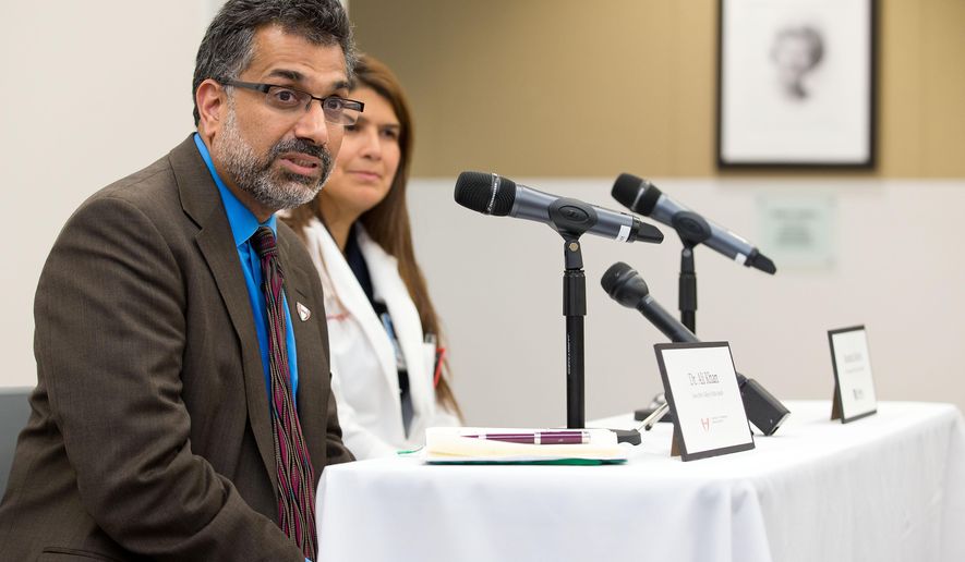 Dr. Ali Khan, left, Dean of the College of Public Health at the Nebraska Medical Center speaks during a news conference in Omaha, Neb., Friday, Oct. 3, 2014, to discuss Ebola patient, journalist Ashoka Mukpo, who is expected to arrive from Liberia at the Medical Center on Monday. Rosanna Morris, Chief Nursing officer, listens at right. (AP Photo/The Omaha World-Herald/Ryan Soderlin) MAGS OUT, TV OUT