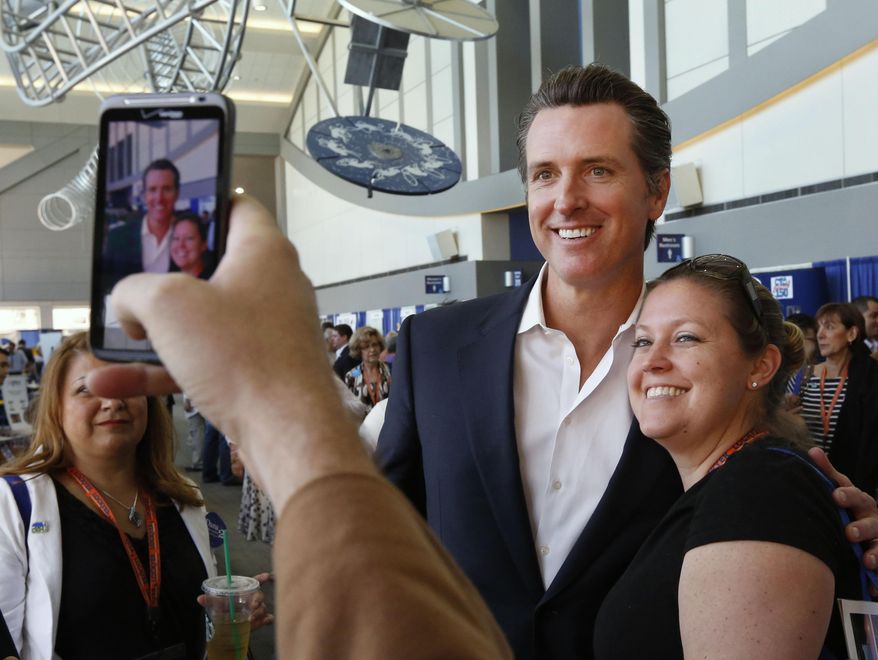 FILE -- In this April 12, 2013 file photo, Lt. Gov. Gavin Newsom poses for a photo with Jennifer Siegert, of Huntington Beach, a delegate to the 2013 Democratic State Convention in Sacramento, Calif. Newsom is being challenged for reelection in the November election by Republican Ron Nehring.(AP Photo/Rich Pedroncelli,file)