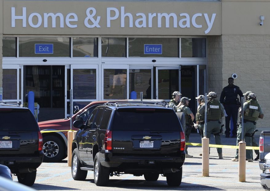 Law enforcement officers work at the scene where a Montgomery Police Officer was shot and wounded trying to apprehend a suspect in a store theft at the Walmart on the East Blvd. in Montgomery, Ala., Sunday, Oct. 5, 2014. Montgomery police say they're searching for a suspect. (AP Photo/Montgomery Advertiser, Mickey Welsh)