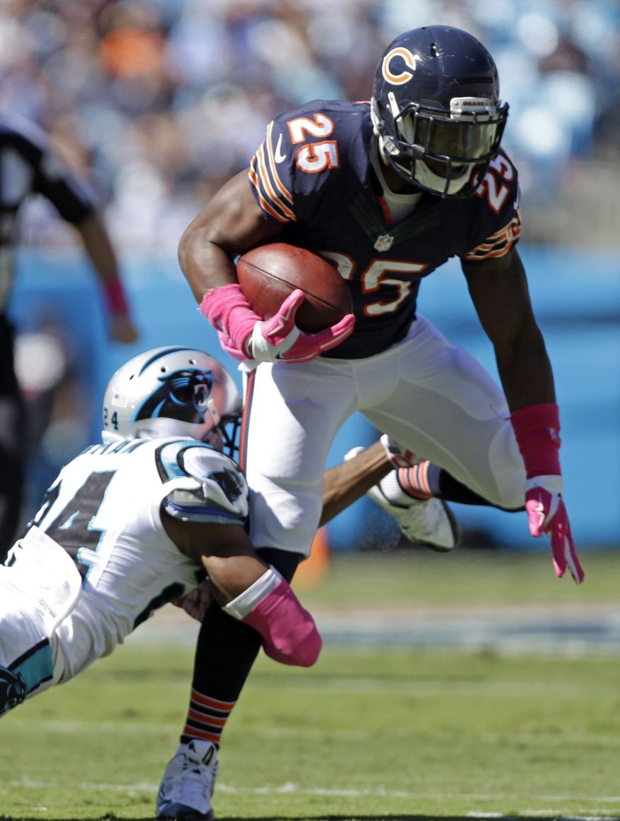 Chicago Bears' Ka'Deem Carey (25) is tackled by Carolina Panthers' Josh Norman (24) during the first half of an NFL football game in Charlotte, N.C., Sunday, Oct. 5, 2014. (AP Photo/Bob Leverone)